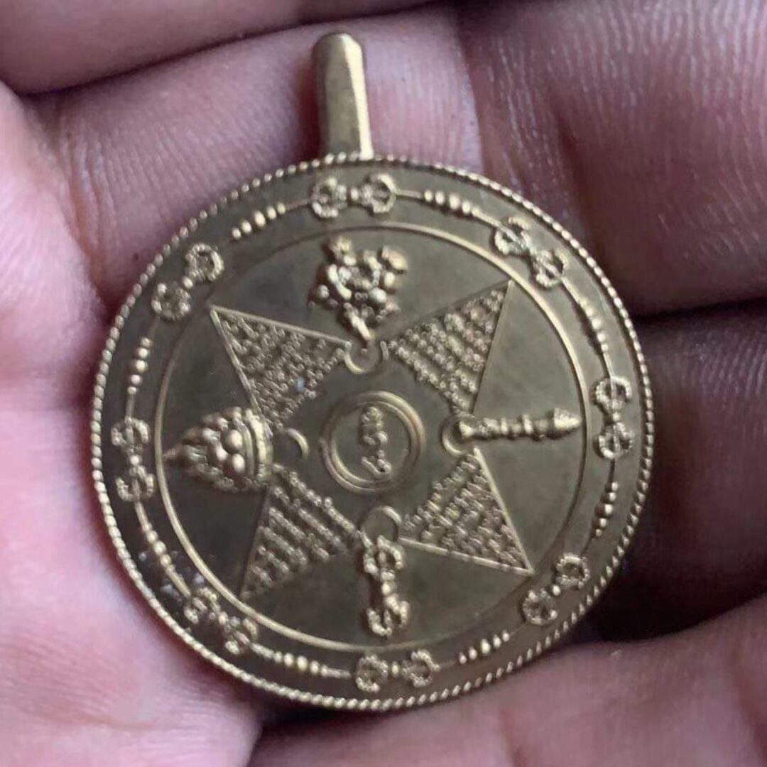 Golden medallion with detailed engravings held.